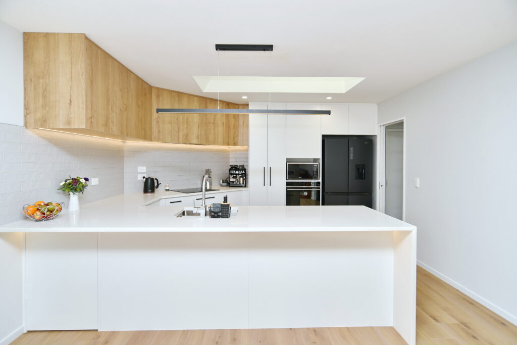 Clean lines and use of contrast between the white surfaces and natural timber cupboards